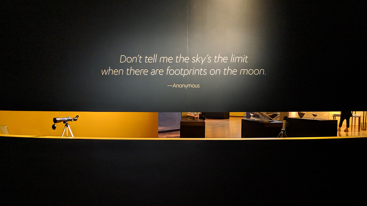 “Don’t tell me the sky’s the limit when there are footprints on the moon” is written on a wall above a window into the gallery.